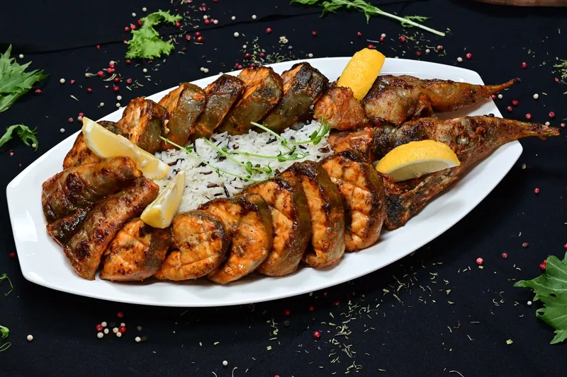 Grilled fish with lemon on a white platter